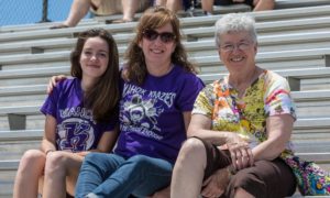 Two women and girl in Kahok Stadium stands