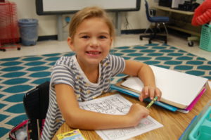 Girl sitting at school desk smiling