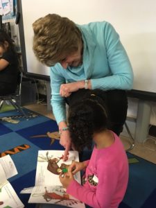 Mary Lee Muniz reads with a Kreitner kindergartner