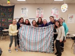 Members of CHS Spanish Club holding a blanket they made for Siteman Cancer Center patients