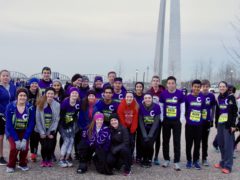 CHS Go St. Louis Half Marathon participants posed in a group photo by the Arch