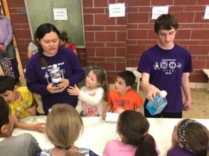 High School students help younger students with experiment